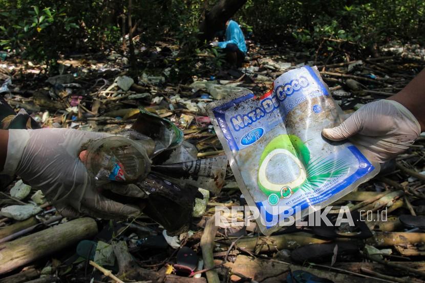 Aktivis lingkungan memungut sampah plastik yang berserakan di Hutan Mangrove Wonorejo, Surabaya, Jawa Timur
