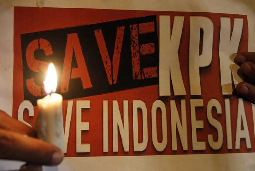Aktivis Masyarakat Sumut Peduli KPK memegang poster ketika melakukan aksi mendukung Komisi Pemberantasan Korupsi (KPK), di kawasan titik nol Kota Medan, Sumatera Utara, Jumat (23/1) 