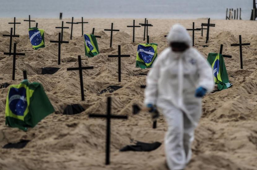 Aktivis meletakkan salib dan bendera Brazil sebagai bentuk protes terhadap penanganan Covid-19 oleh pemerintah Brazil, Kamis (11/6). Jumlah kematian Covid-19 di Brazil telah melebihi Inggris.