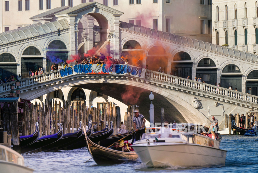 Aktivis menggelar aksi protes di Jembatan Rialto, Venesia, Italia, pada Sabtu, 28 Juni 2025. Mereka mengecam perayaan pernikahan selama tiga hari antara Jeff Bezos dan istrinya, Lauren Sanchez Bezos, yang berlangsung di Venesia pada Jumat lalu, sebagai simbol ketimpangan yang semakin parah dan pengabaian terhadap warga kota.  