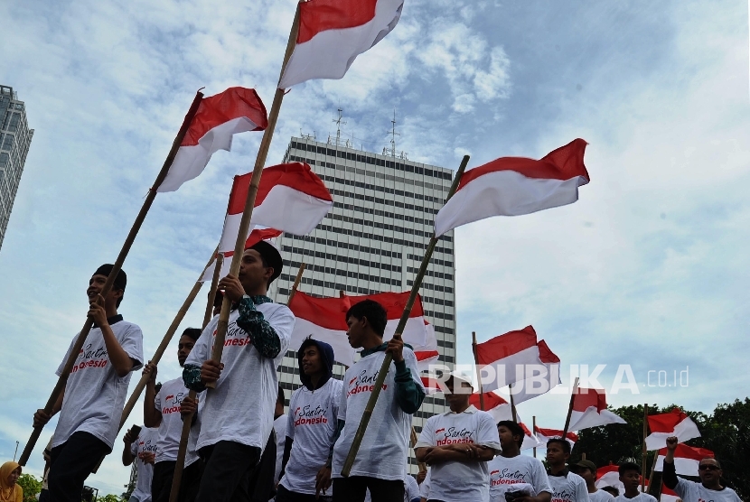 Aktivis Santri Indonesia melakukan aksi membawa bendera merah putih di Bundaran HI, Jakarta, Ahad (2/10).