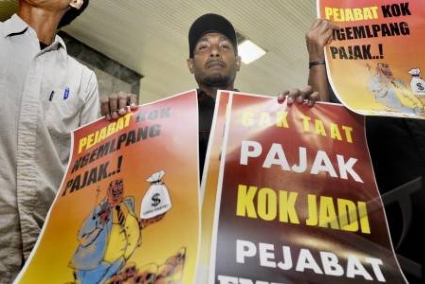 Aktivis yang tergabung dalam Forum Masyarakat Peduli Keadilan (FMPK) membawa poster anti korupsi pajak di Kompleks DPR-RI Senayan, Jakarta.
