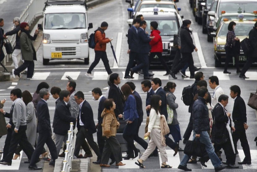 Aktivitas pekerja Jepang di salah satu jalanan Kota Tokyo. Bank of Japan (BOJ) memproyeksi inflasi konsumen inti kemungkinan akan mulai melambat akhir tahun ini karena efek dari lonjakan biaya bahan baku pada masa lalu mulai menghilang.