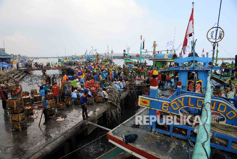 Aktivitas pekerja membongkar muat ikan hasil tangkapan nelayan di Tempat Palelangan Ikan (TPI) Brondong, Lamongan, Jawa Timur, Kamis (6/10)