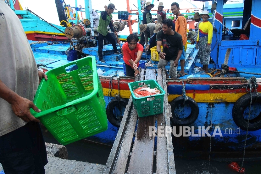 Aktivitas pekerja membongkar muat ikan hasil tangkapan nelayan di Tempat Palelangan Ikan (TPI) Brondong, Lamongan, Jawa Timur, Kamis (6/10)