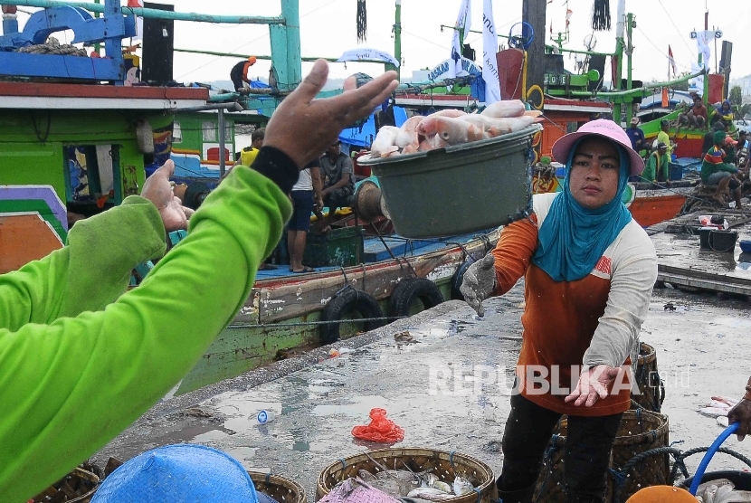 Aktivitas pekerja membongkar muat ikan hasil tangkapan nelayan di Tempat Palelangan Ikan (TPI) Brondong, Lamongan, Jawa Timur, Kamis (6/10)