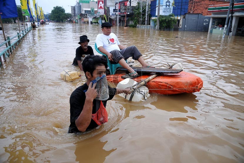 Aktivitas warga di Jalan Abdullah Syafei yang tergenang banjir akibat meluapnya Kali Ciliwung di Kampung Melayu, Jakarta, Sabtu (18/1). (Republika/Prayogi)