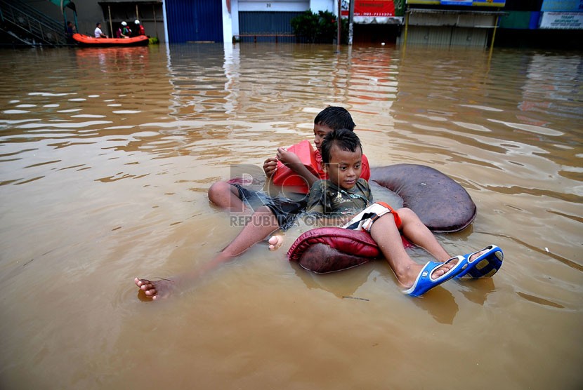 Aktivitas warga di Jalan Abdullah Syafei yang tergenang banjir akibat meluapnya Kali Ciliwung di Kampung Melayu, Jakarta, Sabtu (18/1). (Republika/Prayogi)