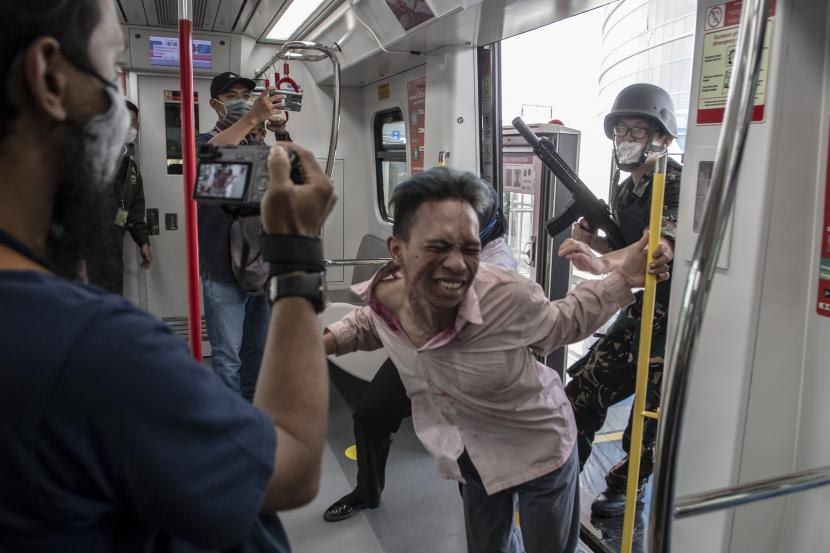 Aktor beraksi menakuti penumpang sarana transportasi Lintas Raya Terpadu (LRT) Jakarta pada wahana zombie Train to Apocalypse di Stasiun LRT, Jakarta, Jumat (12/8/2022). LRT menyediakan dua stasiun untuk wahana 'Train to Apocalypse' hingga 11 September.
