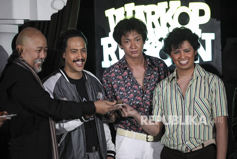 Aktor Indro Warkop menyerahkan potongan tumpeng kepada Randy Danistha (kedua kiri), Adipati Dolken (kedua kanan) dan Aliando Syarief (kanan) pada jumpa pers pemeran baru film Warkop DKI Reborn di Jakarta, Jumat (15/3/2019). 