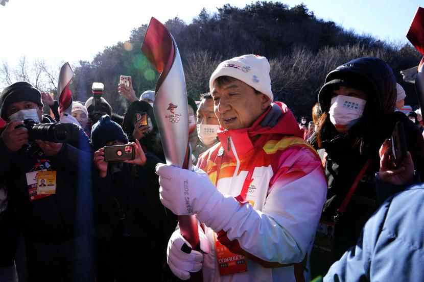 Aktor Jackie Chan membawa obor Olimpiade Musim Dingin dalam pawai obor di Badaling Great Wall, di pinggiran Beijing, China, Kamis (3/2/2022).