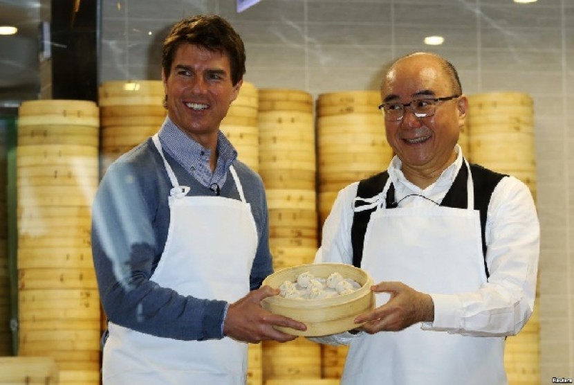 Aktor Tom Cruise berpose bersama Presiden Din Tai Fung Yang Chi-hua dan xiaolongbao, atau dumpling alias pangsit khas restoran tersebut 