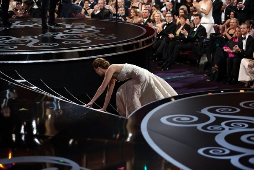Aktris Jennifer Lawrencde terjatuh saat menaiki tangga menuju podium untuk menerima penghargaan sebagai Aktris Terbaik di ajang Academy Awards ke-85