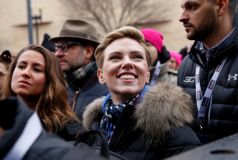 Aktris Scarlett Johansson tersenyum saat berdemonstrasi memprotes Presiden Amerika Serikat Donald Trump, di Washington, Sabtu (21/1).