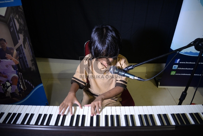 Seorang siswa disabilitas bermain piano 
