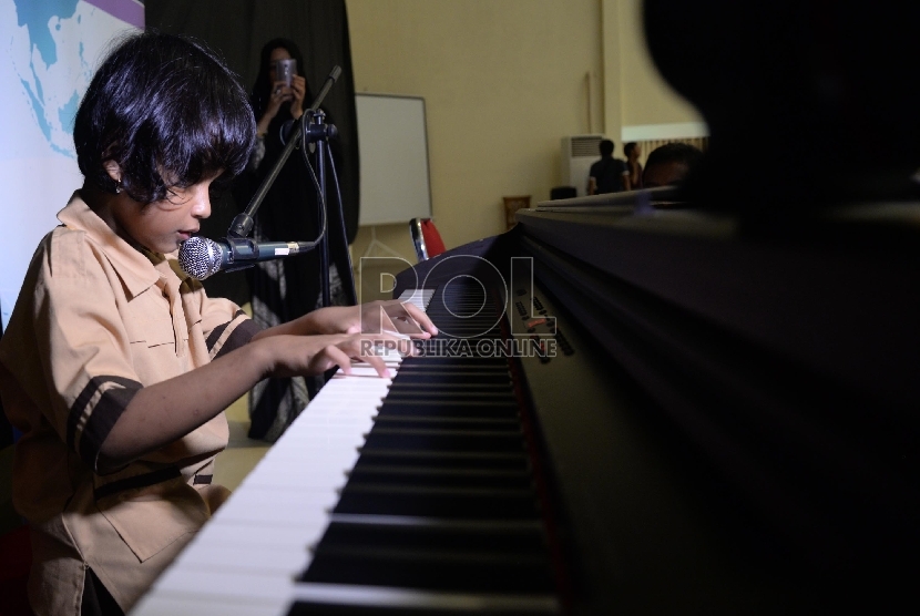 Alafta Hirzi Sadiq (7 tahun) Siswa disabilitas bermain piano sambil bernyanyi di SLB A Pembina, Lebak bulus, Jakarta, Rabu (2/12). 
