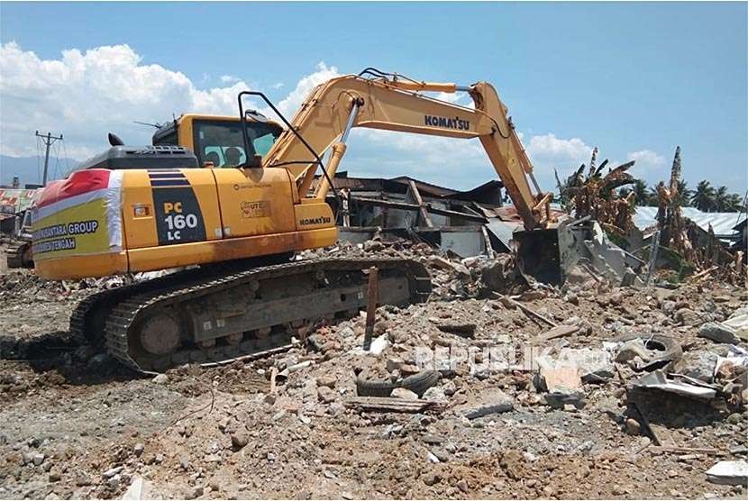 Alat berat bantuan United Tractor Group mengengevakuasi reruntuhan rumah korban gempa di Palu, Rabu (3/10). UT Group memulai pada tahap evakuasi dengan mendatangkan sejumlah alat berat berupa 4 unit excavator, 1 unit bulldozer dan 1 unit lowboy yang beroperasi di lokasi gempa di  Kelurahan Balaroa, Palu, Sulawesi Tengah. 