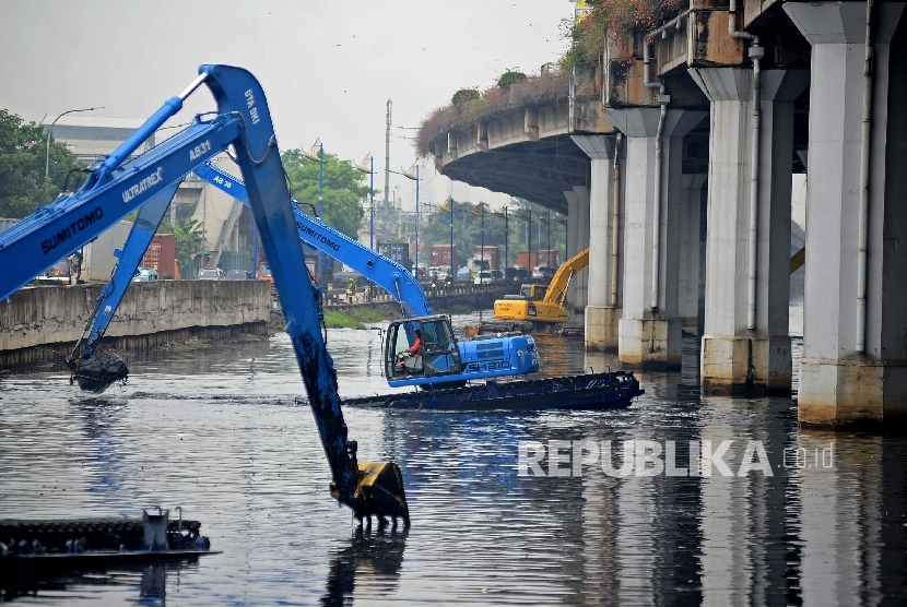 Alat berat dioperasikan untuk mengeruk lumpur yang mengendap di Kali Ancol, Jakarta Utara, Jumat (13/1).