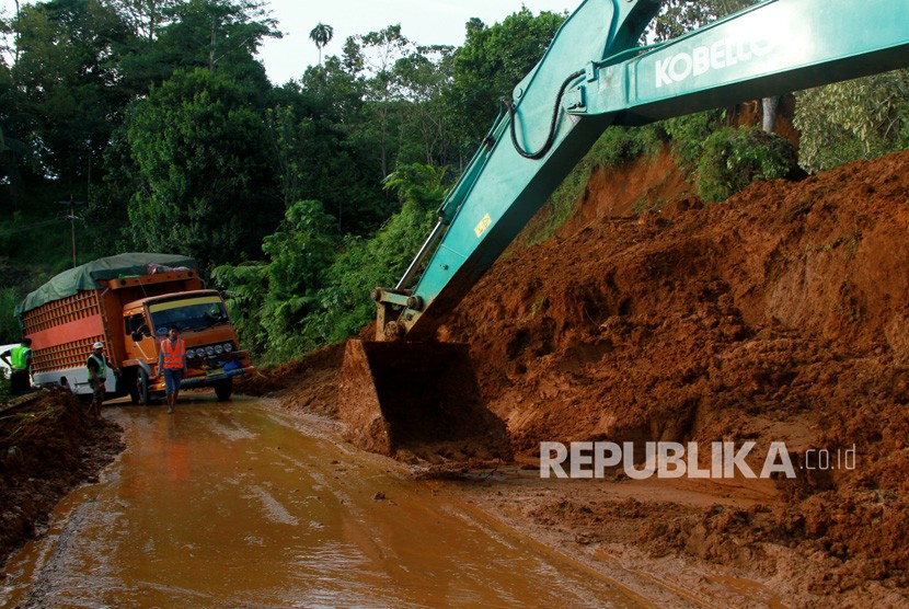 Alat berat eskavator membersihkan badan jalan yang tertutup longsor di jalan Trans Sulawesi. Ilustrasi.