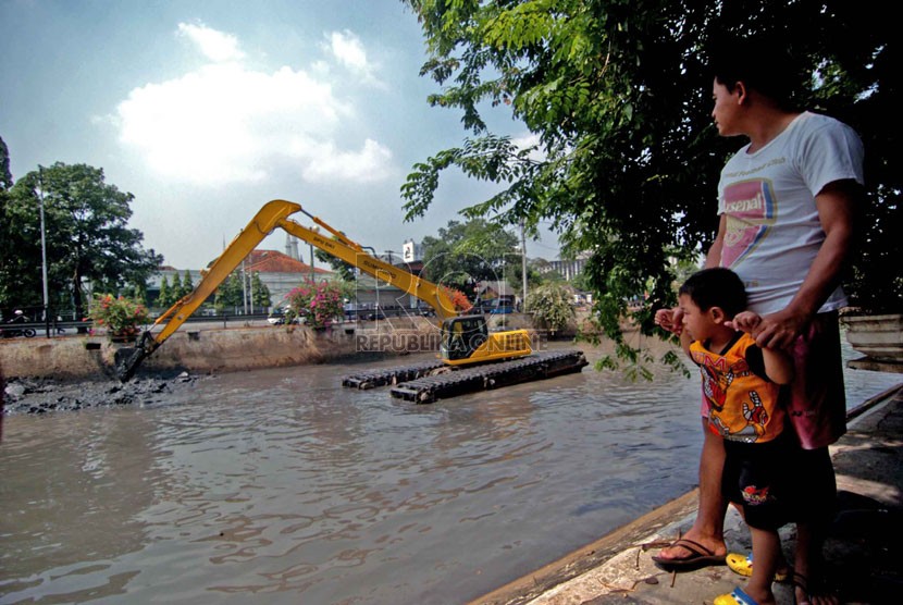   Warga menyaksikan alat berat yang mengeruk lumpur di aliran anak kali Ciliwung, Pasar Baru, Jakarta Pusat, Rabu (10/9). (Republika/Raisan Al Farisi)