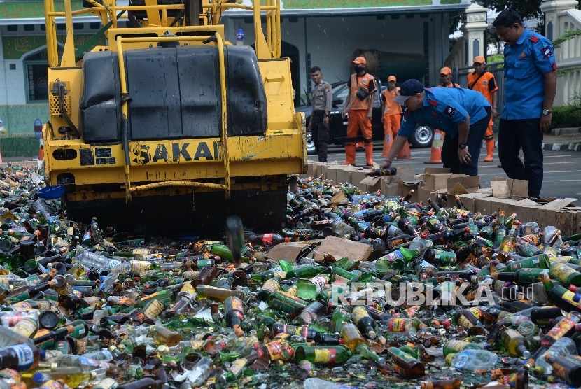 Alat berat menggilas puluhan ribu botol minuman keras (miras) saat pemusnahan di halaman Polres Metro Jakarta Selatan, Kamis (2/6)