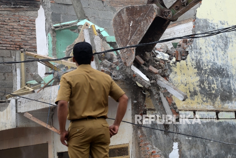  Alat berat menghancurkan bangunan tempat tinggal yang berada di pinggiran sungai Ciliwung kawasan Bukit Duri, Jakarta, Selasa (12/1).