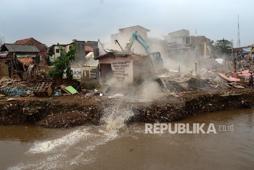 Alat berat menghancurkan bangunan tempat tinggal yang berada di pinggiran sungai Ciliwung kawasan Bukit Duri, Jakarta, Selasa (12/1).