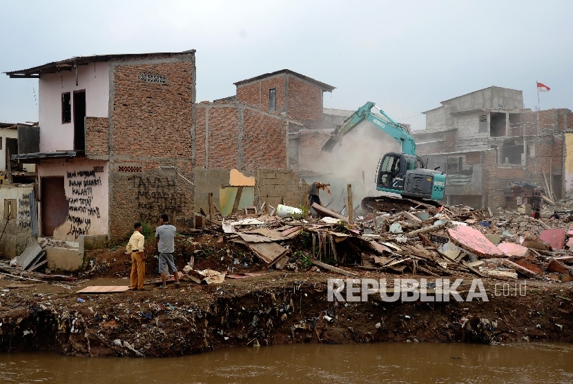 Alat berat menghancurkan bangunan tempat tinggal yang berada di pinggiran sungai Ciliwung kawasan Bukit Duri, Jakarta, Selasa (12/1).