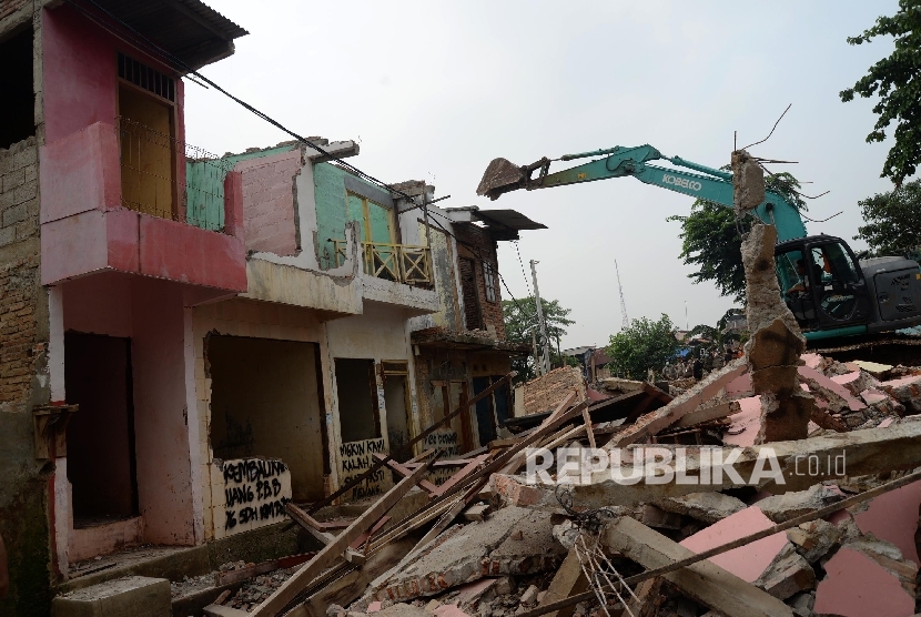 Alat berat menghancurkan bangunan tempat tinggal yang berada di pinggiran sungai Ciliwung kawasan Bukit Duri, Jakarta, Selasa (12/1).
