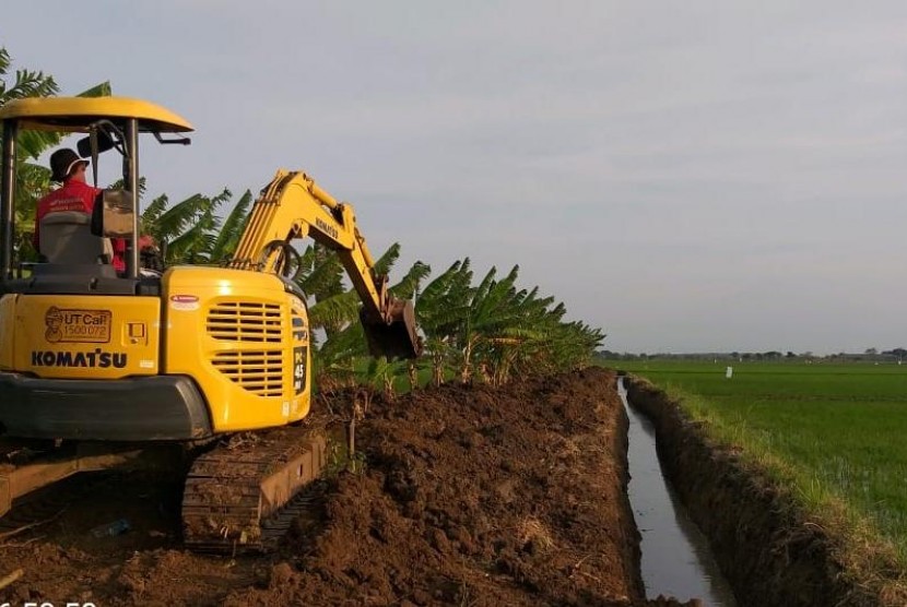 Alat berat sedang meratakan tanah untuk pertanian