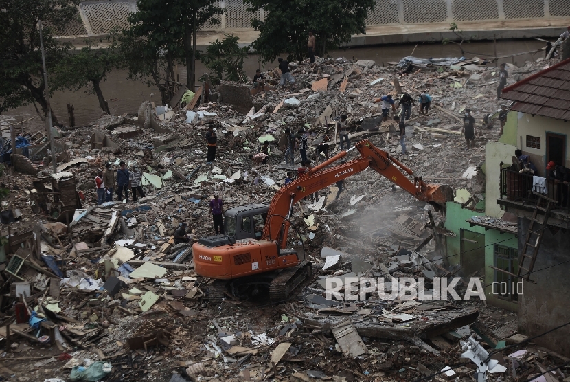 Alat berat yang dioperasikan oleh petugas merobohkan sebuah rumah saat penggusuran di pemukiman proyek normalisasi Sungai Ciliwung, Bukit Duri, Jakarta, Rabu (28/9)