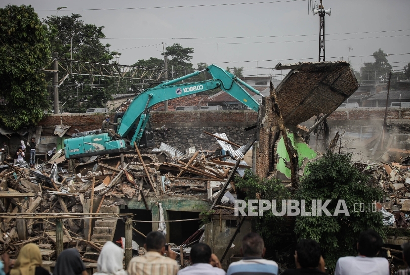 Alat berat yang diopersikan oleh petugas menghancurkan sebuah rumah saat penggusuran di permukiman yang terkena proyek normalisasi Sungai Ciliwung, Bukit Duri, Jakarta. (ilustrasi)