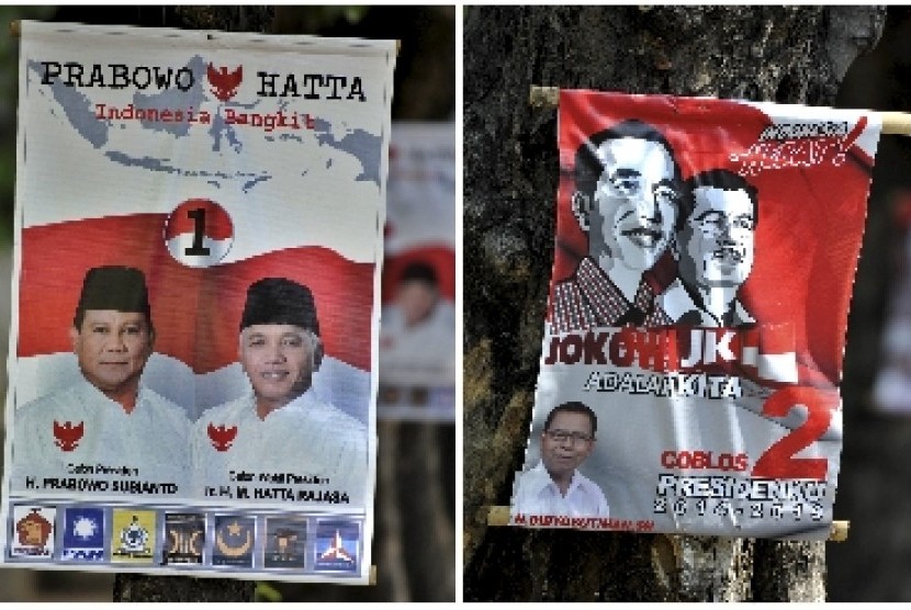 Alat peraga kampanye (APK) bergambar dua pasangan Capres-Cawapres, Prabowo-Hatta (atas) dan Jokowi-JK (bawah), terpasang di pohon, di Semarang, Jateng, Rabu (2/7). 