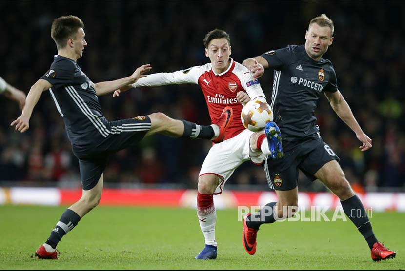 Aleksandr Golovin (kiri) dan  Aleksei Berezutski (kanan) mengepung Mesut Ozil (tengah), pada pertandigan perempat fiinal Liga Eropa di Emirates stadium, London, Jumat (6/4) dini hari.