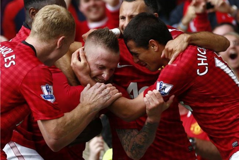 Alexander Buttner (tengah), pemain sayap Manchester United, merayakan golnya bersama rekan setim saat menjamu Wigan Athletic di laga Liga Primer Inggris di Old Trafford, Manchester, Sabtu (15/9). 