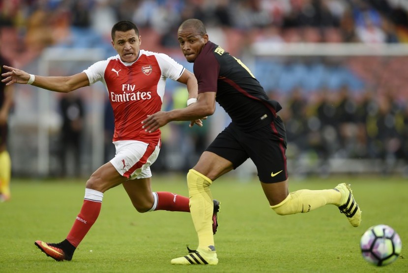  Alexis Sanchez sedang berebut bola dengan pemain Manchester City Fernando