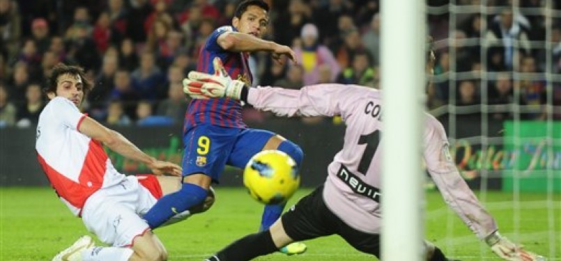  Alexis Sanchez (tengah), striker Barcelona asal Chile, menjebol jala kiper Rayo Vallecano, David Cobeno, di laga La Liga Spanyol di Camp Nou, Barcelona, Selasa (29/11) 