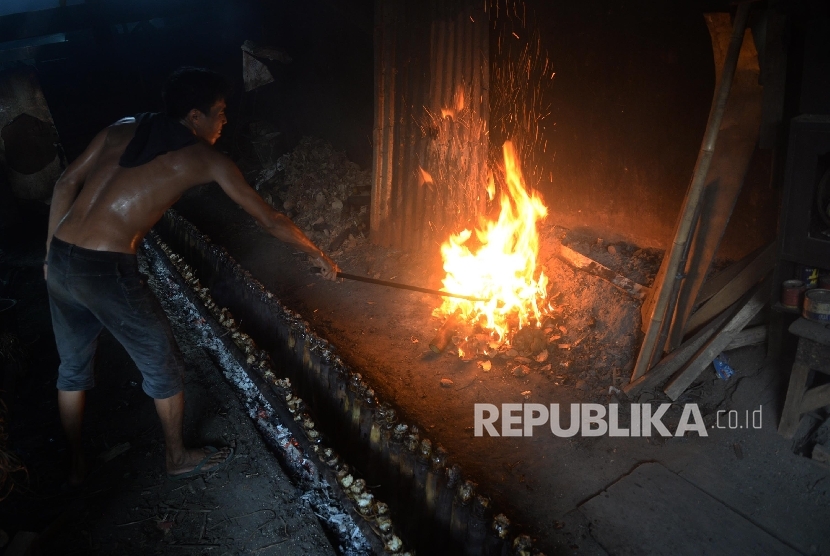 Ali Nuryono membakar batok kelapa sebagai bahan untuk membakar lemang bambu (penganan dari beras ketan khas Sumatera Barat) di Kawasan Pasar Senen, Jakarta, Jumat (2/6). P