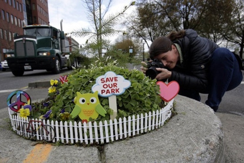 Allison Wildman crouches low to get a photo of Mill Ends Park in Portland on April 11, 2013. 