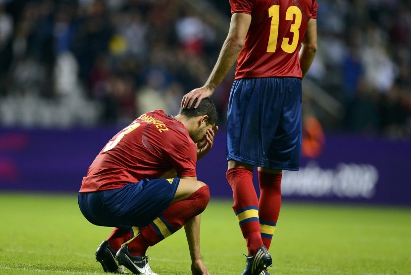 Alvaro Dominguez (kiri), pemain timnas Spanyol, tertunduk lesu setelah menelan kekalahan dari Honduras di laga Grup D cabang sepakbola putra Olimpiade 2012 London di St James Park, Newcastle, Ahad (29/7). 