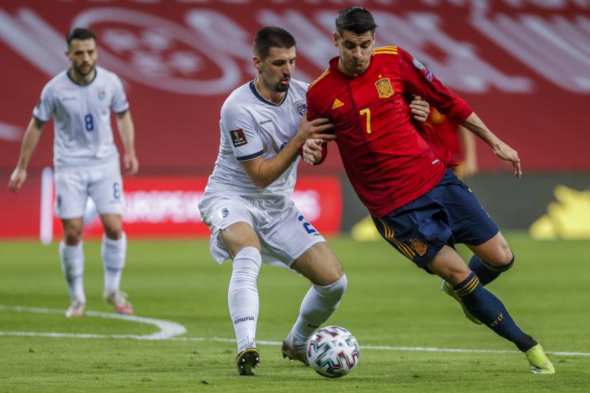 Striker timnas Spanyol Alvaro Morata (kanan) duel perebutan bola dengan Ibrahim Dresevic dari Kosovo selama pertandingan sepak bola babak kualifikasi Grup B Piala Dunia 2022 antara Spanyol dan Kosovo di Stadion La Cartuja di Seville, Spanyol, Kamis (1/4).