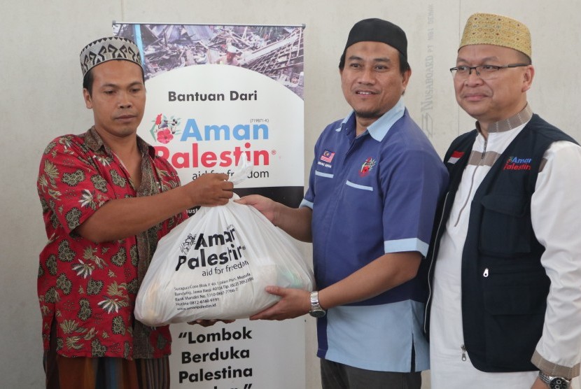 Aman Palestin-Indonesia menyerahkan bantuan kepada korban gempa Lombok. Direktur Aman Palestin-Indonesia, Ustaz Miftahuddin (kanan).