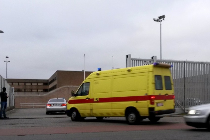 Ambulans berwarna kuning diduga membawa tersangka teror Paris yang paling dicari Salah Abdeslam ke sebuah penjara di Bruges, Prancis, (19/3).