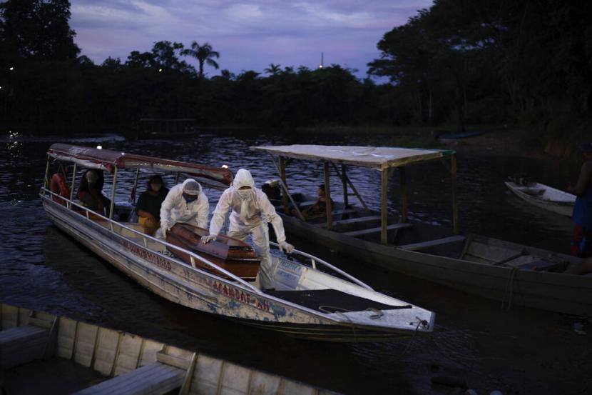 Amerika Latin Jadi Episenter Baru Covid-19. Petugas pengurus jenazah membawa jenazah suspek Covid-19 dengan perahu di Manaus, Brasil, 14 Mei lalu. 