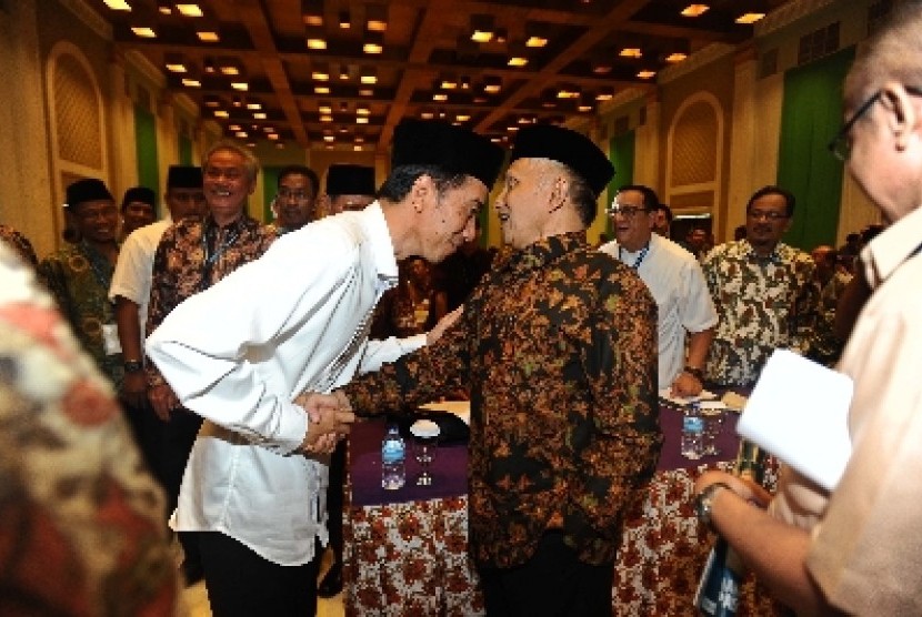 Amien Rais berjabat tangan dengan Jokowi.