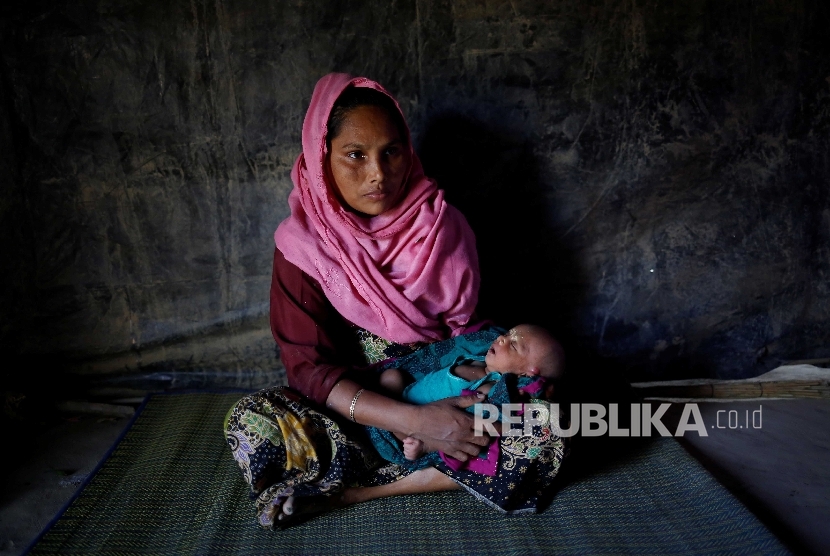 Amina, 30, menggendong bayi perempuannya yang berumur 16 hari di sebuah  Kamp Pengungsian Kutupalang Bangladesh.