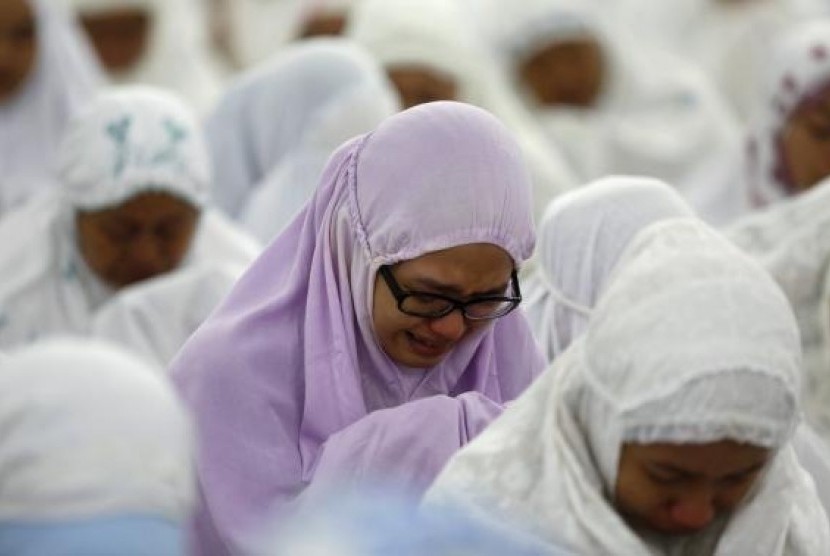 An Acehnese woman cries as she attends a mass prayer for the 2004 tsunami victims at Baiturrahman Grand Mosque in Banda Aceh, December 25, 2014.