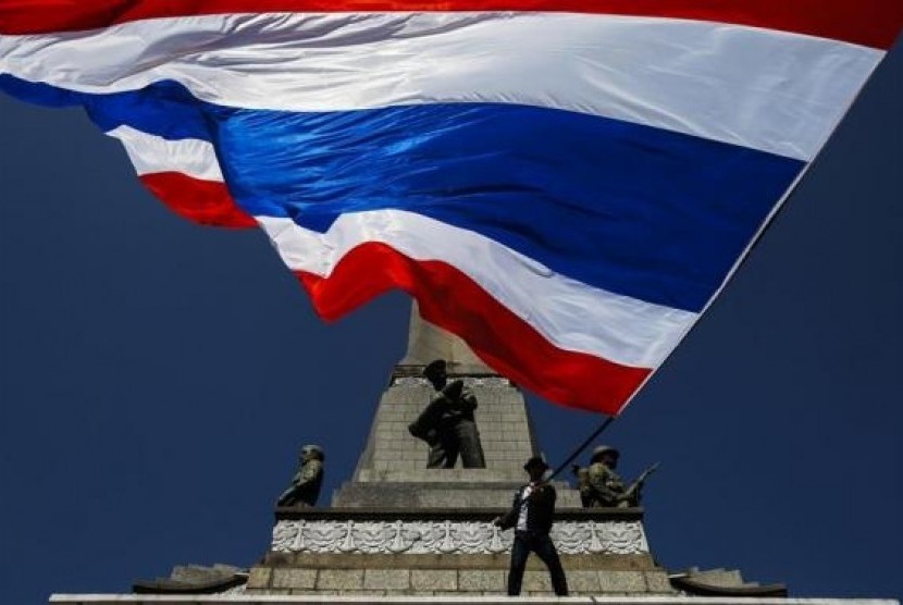 An anti-government protester waves a Thai national flag at Victory Monument in central of Bangkok January 13, 2014.