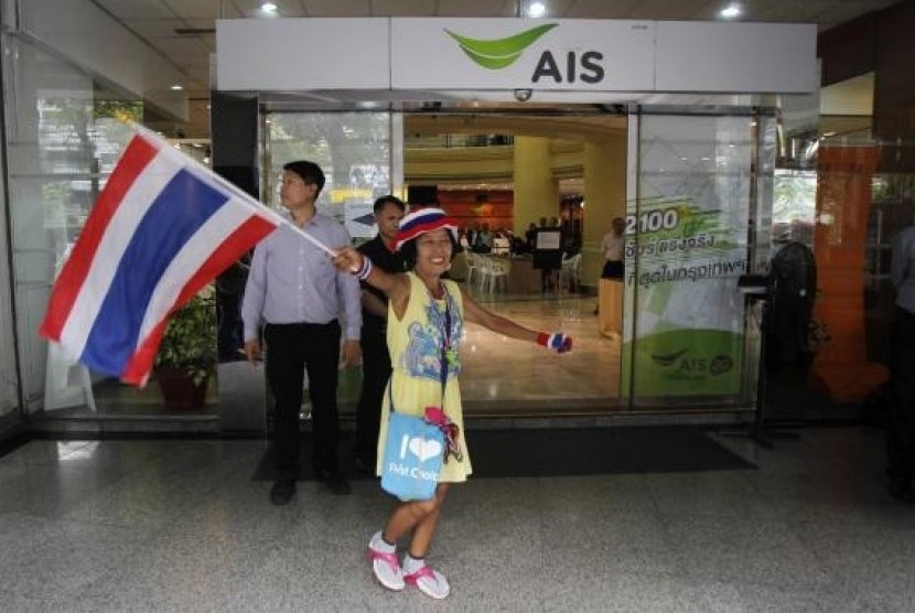 An anti-government protester waves a Thai national flag during a rally at the Shinawatra building in central Bangkok March 10, 2014.