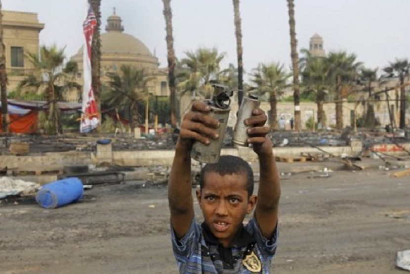 An Egyptian child displays empty tear gas canisters among the debris of a protest camp in Nahda Square, near Cairo University in Giza, Cairo, Egypt, Thursday, Aug. 15, 2013. (file photo)